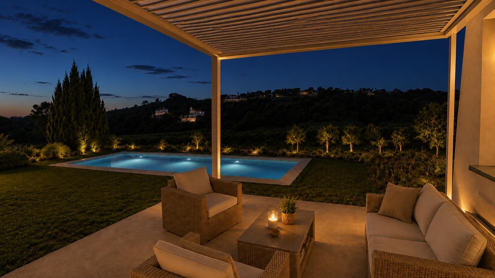 Piscina illuminata di sera vista dal portico
